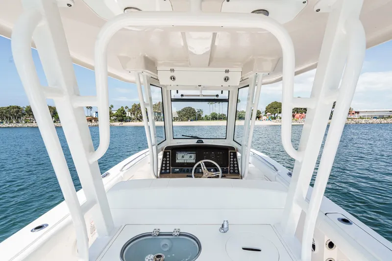 Slide: The Image of 2020 Robalo R272 Center Console boat interior with steering wheel and dashboard on water. - 12