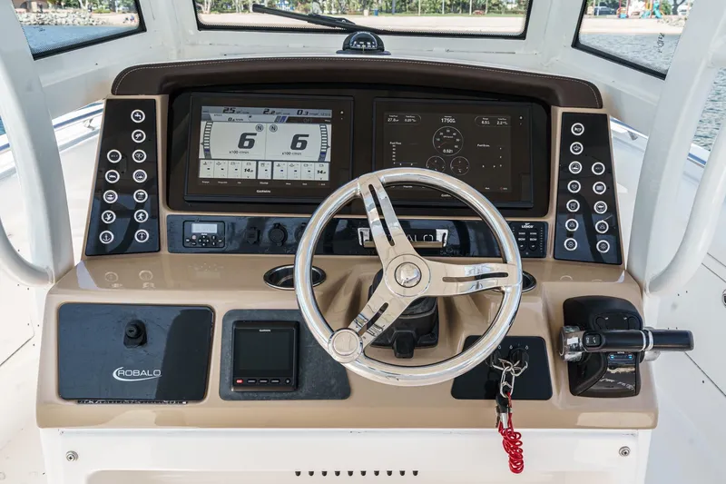 Slide: The Image of 2020 Robalo R272 Center Console boat dashboard with steering wheel and navigation displays. - 14