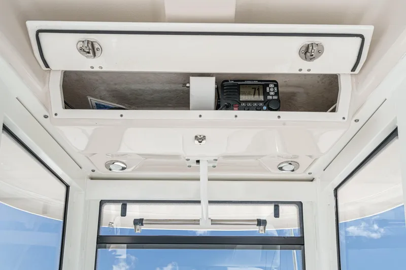 Slide: The Image of 2020 Robalo R272 Center Console boat interior with storage compartment and radio equipment. - 15