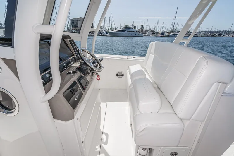 Slide: The Image of 2020 Robalo R272 Center Console boat interior with white seating and steering wheel. - 16