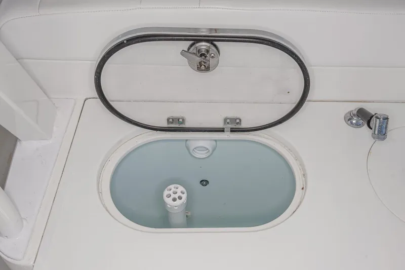 Slide: The Image of 2020 Robalo R272 Center Console livewell with open lid and faucet. - 20