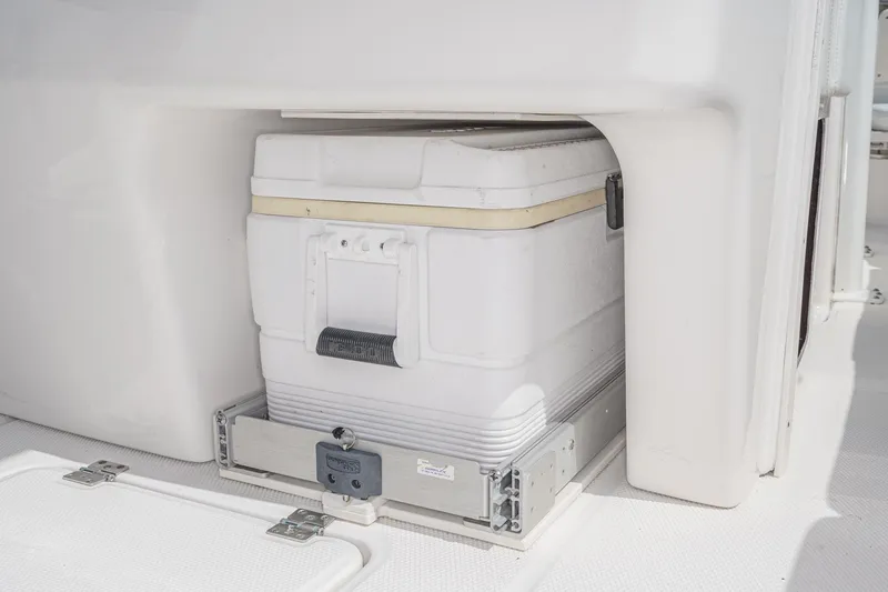 Slide: The Image of 2020 Robalo R272 Center Console cooler storage compartment with sliding mechanism. - 21