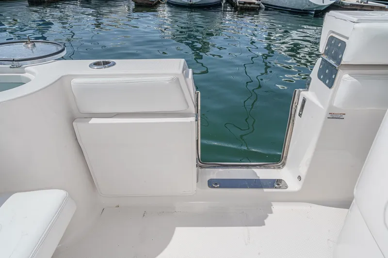 Slide: The Image of 2020 Robalo R272 Center Console boat with open side door at marina. - 27