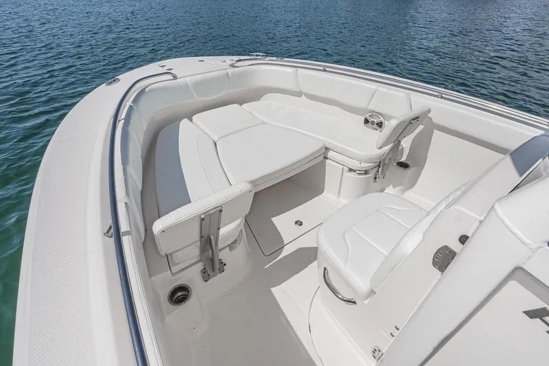 Slide: The Image of 2020 Robalo R272 Center Console boat interior with white seating and table on water. - 32