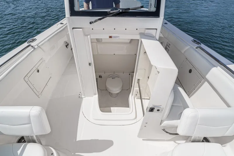 Slide: The Image of 2020 Robalo R272 Center Console boat with open marine toilet compartment. - 37