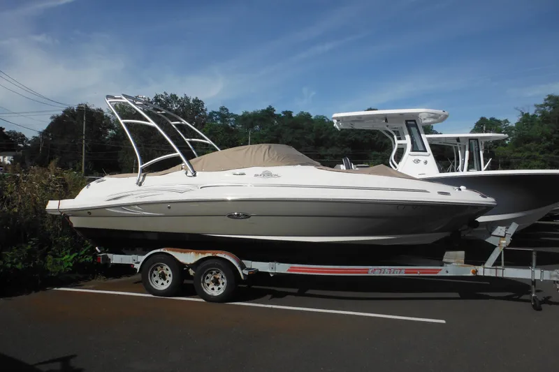 The Image of 2005 Sea Ray 220 Sundeck boat on trailer, parked outdoors. - 0