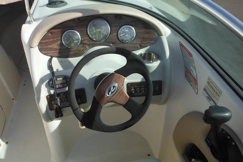 Slide: The Image of Steering console of a 2005 Sea Ray 220 Sundeck boat with gauges and controls. - 18