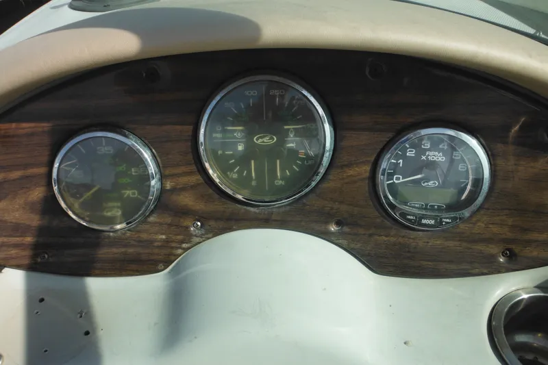 Slide: The Image of Dashboard of a 2005 Sea Ray 220 Sundeck boat with gauges and wood finish. - 21
