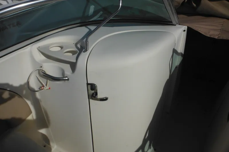 Slide: The Image of 2005 Sea Ray 220 Sundeck interior with cup holders and storage compartment. - 22