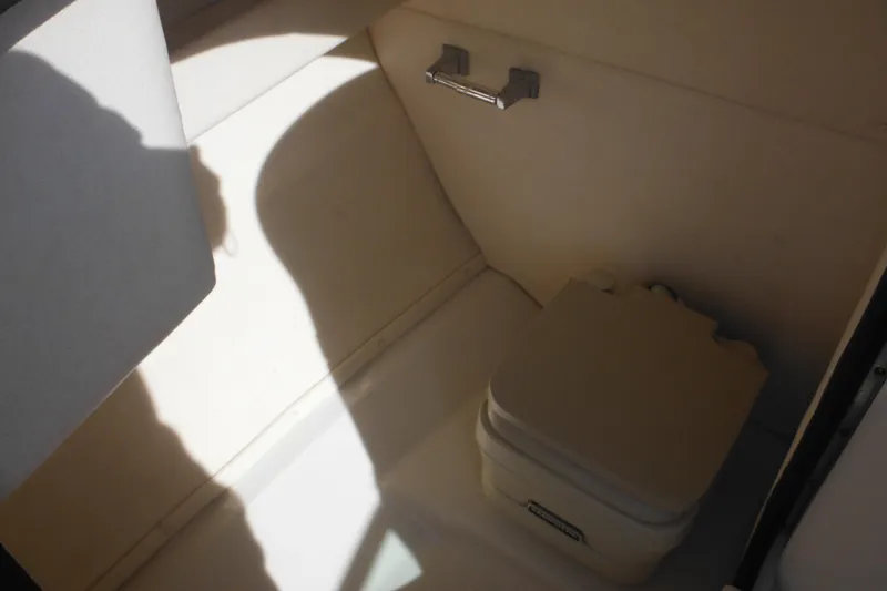 Slide: The Image of Interior of 2005 Sea Ray 220 Sundeck with portable toilet and storage space. - 24