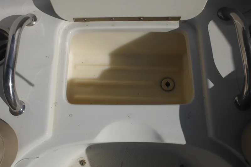 Slide: The Image of 2005 Sea Ray 220 Sundeck boat interior with storage compartment and metal handles. - 37