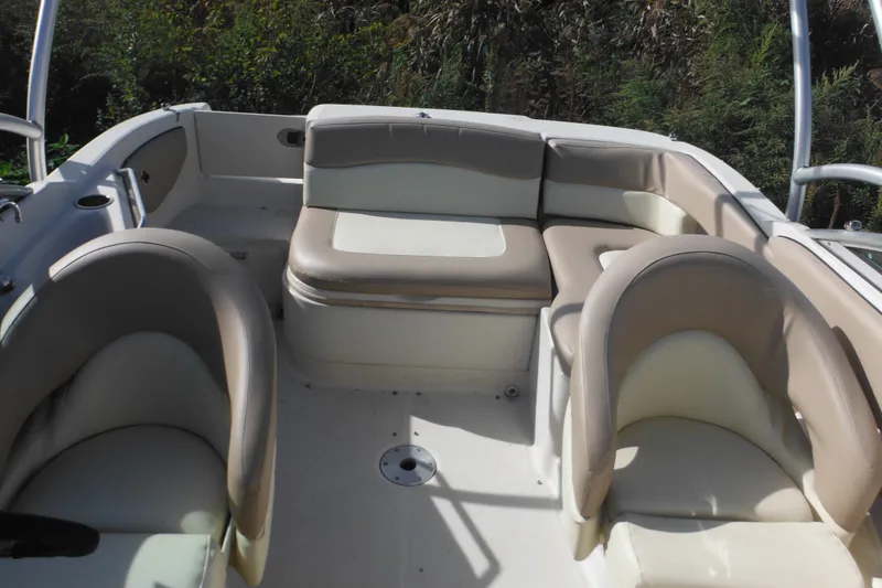 Slide: The Image of 2005 Sea Ray 220 Sundeck interior with beige seating and cup holders. - 7