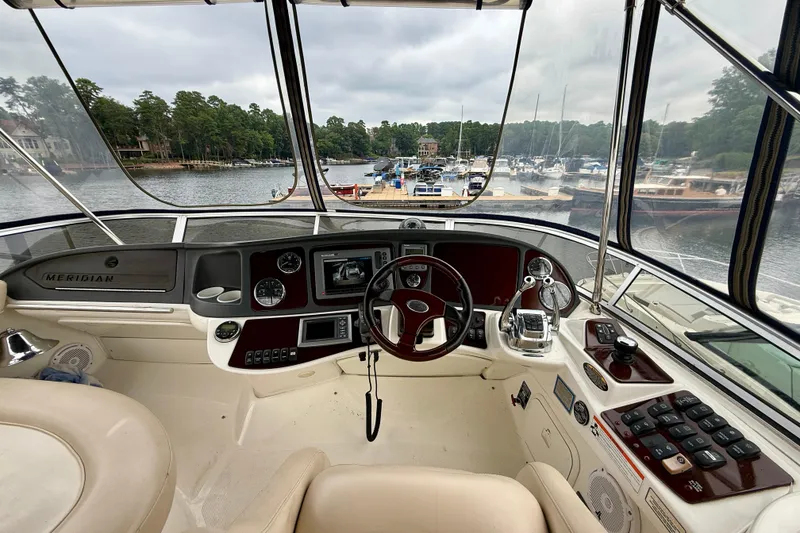 Slide: The Image of Interior view of 2011 Meridian 341 Sedan yacht cockpit with marina backdrop. - 11