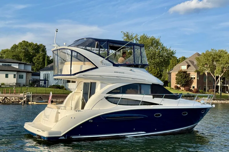 Slide: The Image of 2011 Meridian 341 Sedan yacht cruising on a lake near waterfront homes. - 3