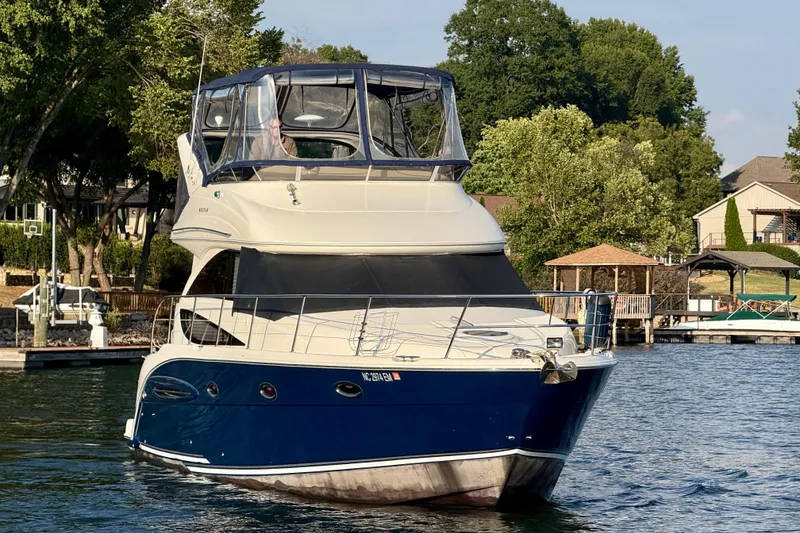 Slide: The Image of 2011 Meridian 341 Sedan yacht on a serene lake with lush greenery. - 5