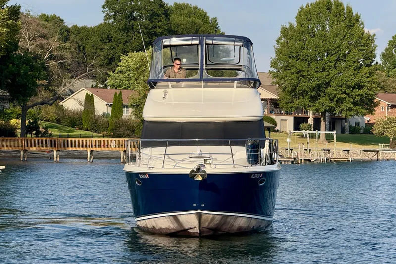 Slide: The Image of 2011 Meridian 341 Sedan yacht cruising on a serene lake near waterfront homes. - 6