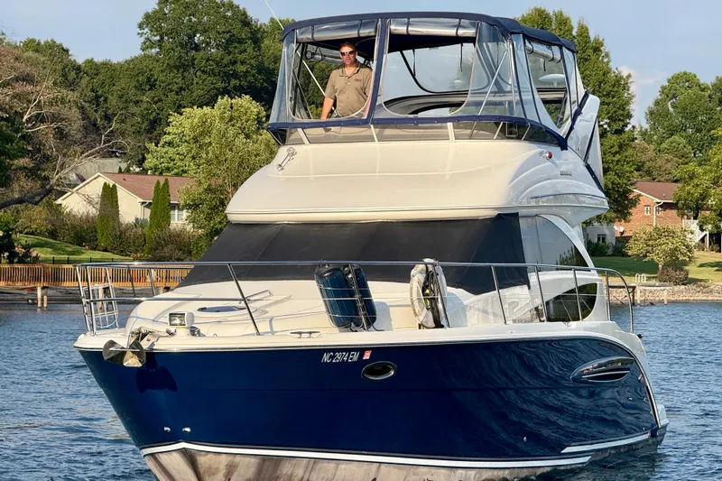 Slide: The Image of 2011 Meridian 341 Sedan yacht on a serene lake with lush greenery. - 7