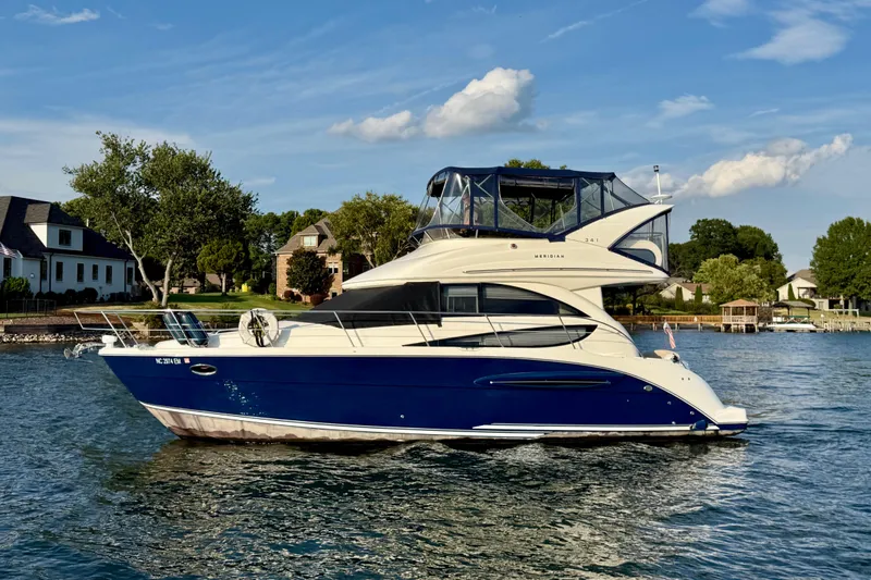 Slide: The Image of 2011 Meridian 341 Sedan yacht cruising on a scenic lake with waterfront homes. - 8