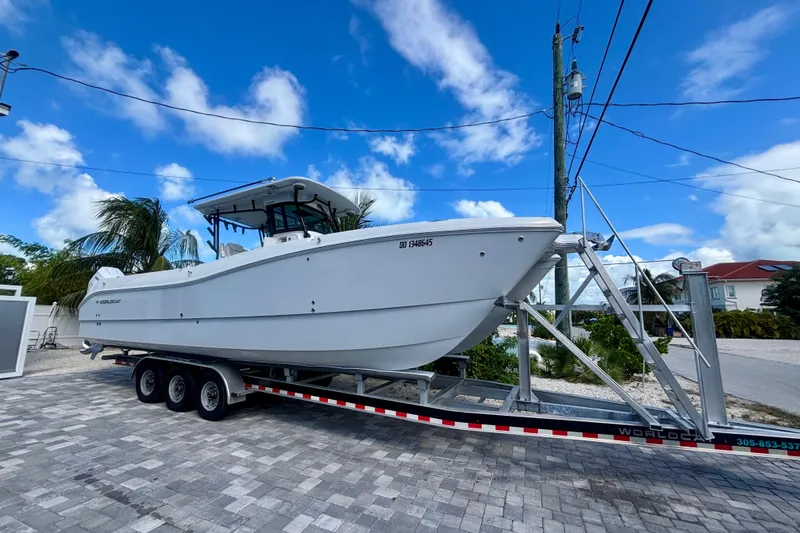 Slide: The Image of 2024 World Cat 325 CC boat on trailer under clear blue sky. - 1