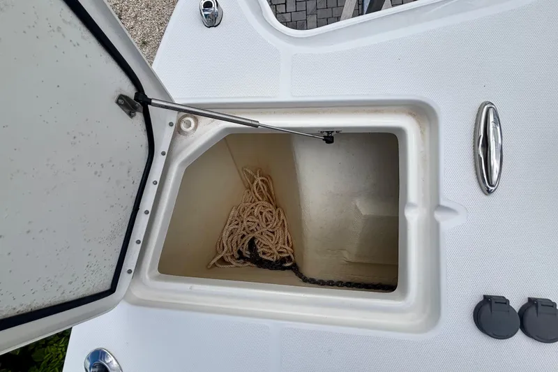 Slide: The Image of Open storage compartment on 2024 World Cat 325 CC boat with rope and chain inside. - 19