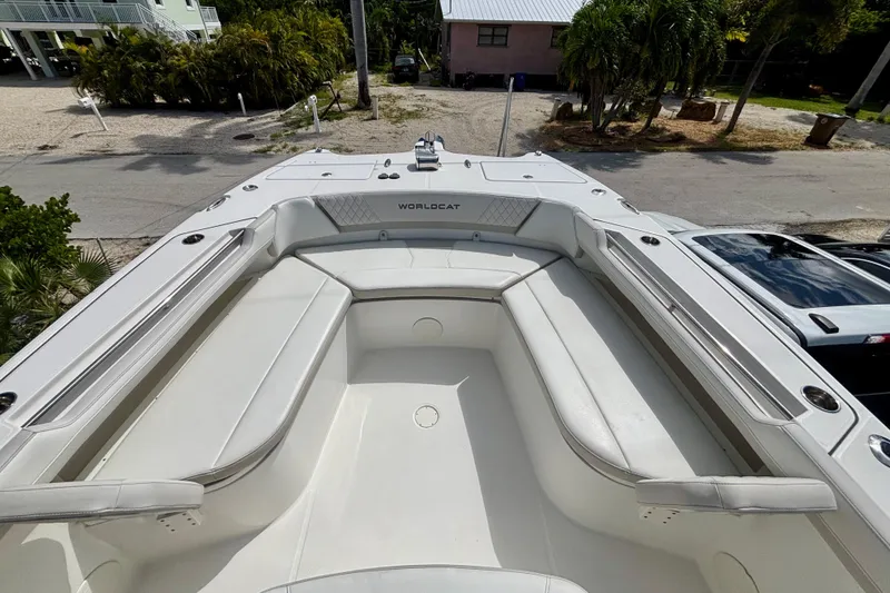 Slide: The Image of 2024 World Cat 325 CC boat with spacious white seating area, docked near tropical surroundings. - 22