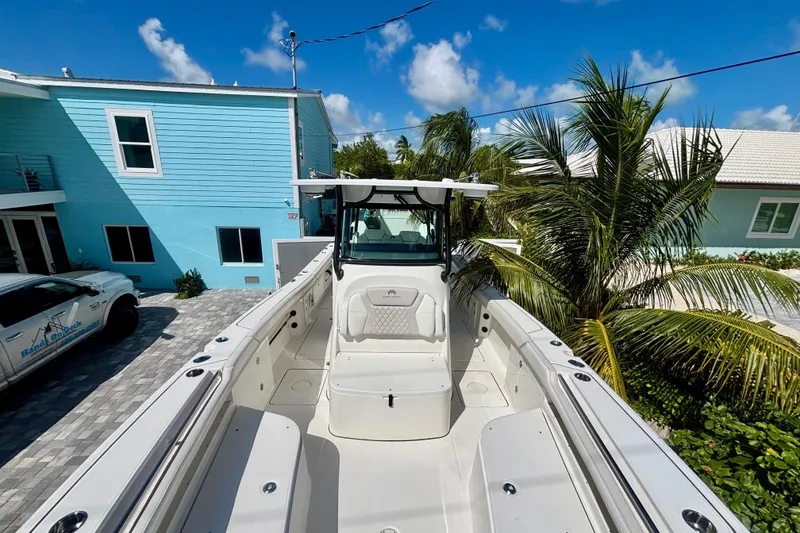 Slide: The Image of 2024 World Cat 325 CC boat docked near tropical house and palm trees. - 26