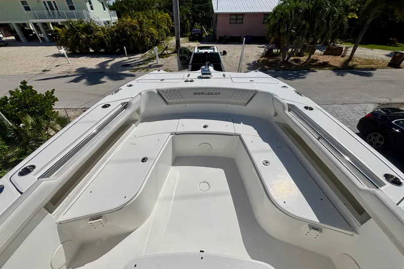 Slide: The Image of 2024 World Cat 325 CC boat deck, spacious seating, and sleek design in a sunny outdoor setting. - 27