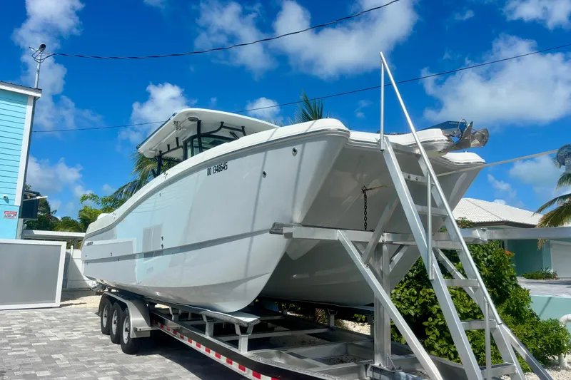 Slide: The Image of 2024 World Cat 325 CC boat on trailer under clear blue sky. - 3