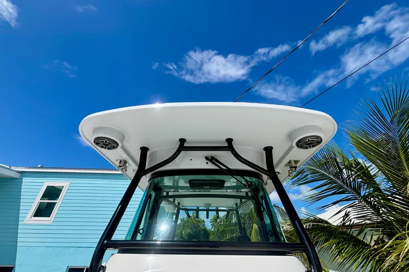 Slide: The Image of 2024 World Cat 325 CC boat with T-top, speakers, and clear blue sky background. - 32