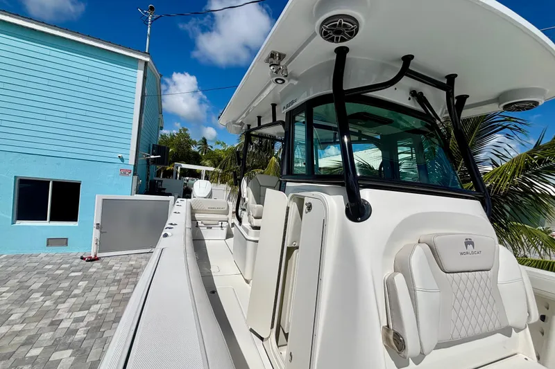 Slide: The Image of 2024 World Cat 325 CC boat docked near a blue building under a clear sky. - 33