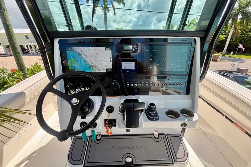 Slide: The Image of 2024 World Cat 325 CC boat dashboard with navigation screens and steering wheel. - 36