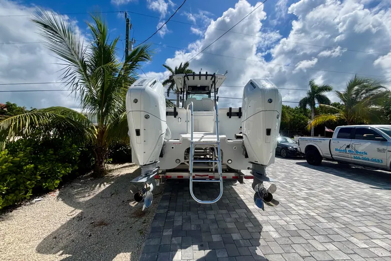 Slide: The Image of 2024 World Cat 325 CC boat with dual engines, parked on a sunny day. - 4