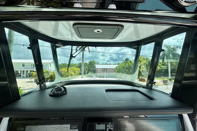 Slide: The Image of 2024 World Cat 325 CC helm view with windshield and dashboard controls. - 45