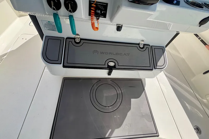 Slide: The Image of 2024 World Cat 325 CC boat interior with branded storage compartments and control panel. - 46