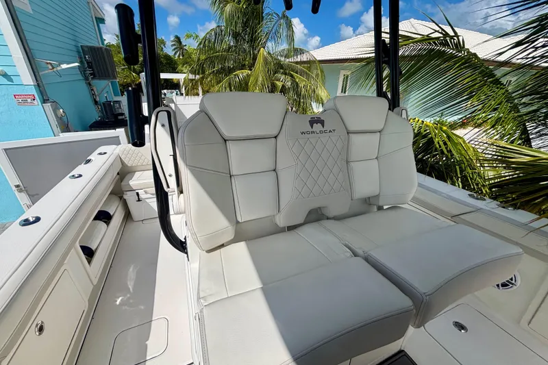 Slide: The Image of 2024 World Cat 325 CC boat interior with white seating and tropical background. - 49