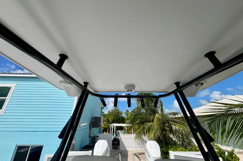 Slide: The Image of 2024 World Cat 325 CC boat interior with T-top, tropical background. - 50