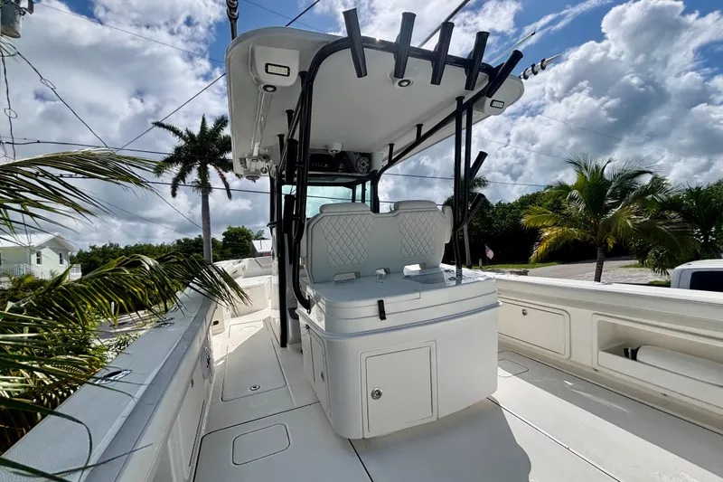 Slide: The Image of 2024 World Cat 325 CC boat with sleek design, palm trees, and blue sky background. - 51