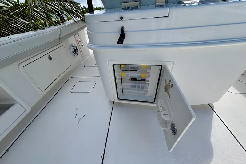 Slide: The Image of 2024 World Cat 325 CC boat interior with open storage compartment and speaker. - 55