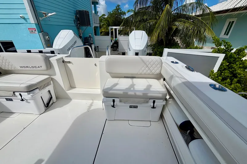 Slide: The Image of 2024 World Cat 325 CC boat interior with cushioned seating and Yeti coolers. - 57