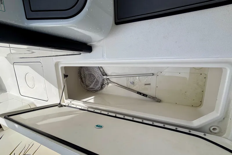Slide: The Image of 2024 World Cat 325 CC boat storage compartment with fishing net inside. - 58