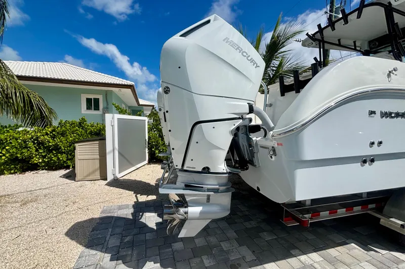 Slide: The Image of 2024 World Cat 325 CC boat with Mercury outboard engine, parked on a sunny driveway. - 6