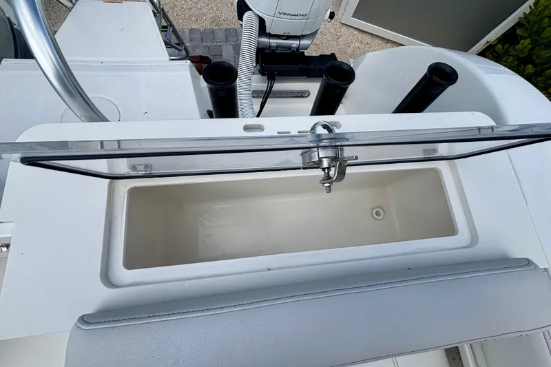 Slide: The Image of 2024 World Cat 325 CC boat with open storage compartment and fishing rod holders. - 61