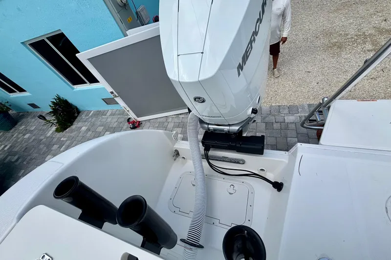 Slide: The Image of 2024 World Cat 325 CC boat with Mercury engine, docked near a blue building. - 64