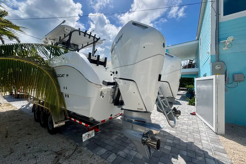 Slide: The Image of 2024 World Cat 325 CC boat with dual engines parked on a driveway. - 8