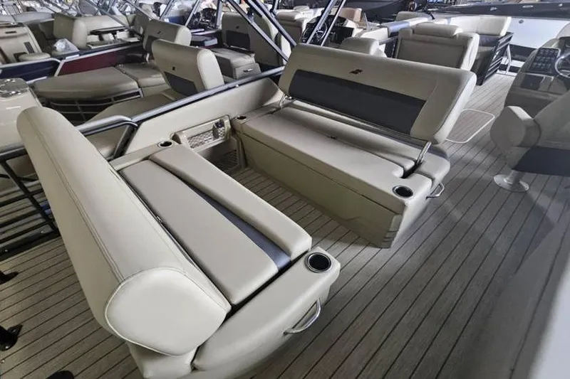 Slide: The Image of Luxurious seating on 2026 Starcraft CX 23 DL pontoon boat, featuring beige upholstery and cup holders. - 9