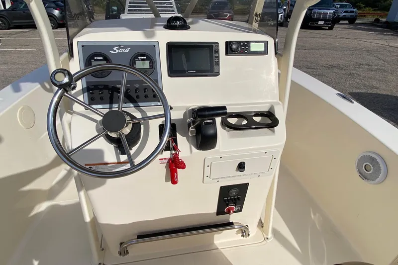 Slide: The Image of 2018 Scout 195 Sportfish boat interior with beige seating and steering wheel. - 10