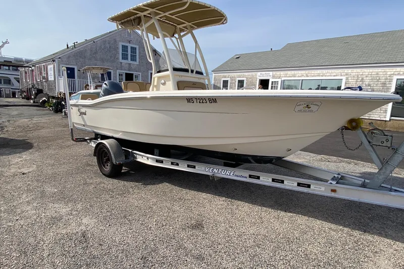 Slide: The Image of 2018 Scout 195 Sportfish boat with Yamaha engine, parked outdoors under clear sky. - 3