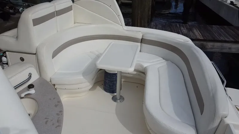 Slide: The Image of 2005 Sea Ray 320 Sundancer boat interior with white seating and table. - 10
