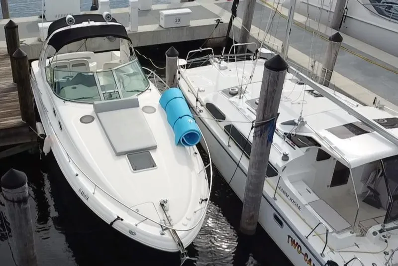 Slide: The Image of 2005 Sea Ray 320 Sundancer docked beside another boat in a marina. - 13