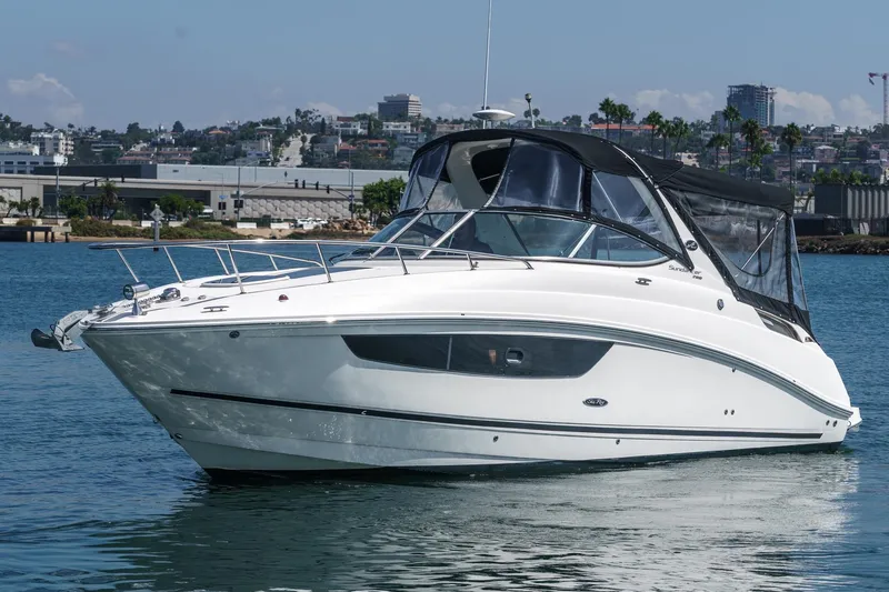 The Image of 2016 Sea Ray 280 Sundancer boat on calm water, cityscape background. - 1
